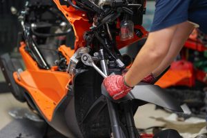 Mechanic Using A Wrench And Socket On The Engine Of A Motorcycle