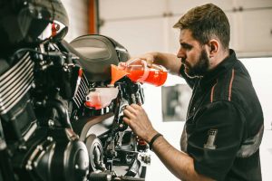 Professional Mechanic Pouring Antifreeze Into A Motorcycle